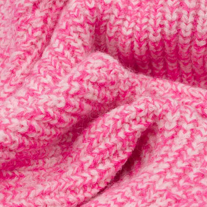 Close-up of pink and white polar fleece knit fabric from dog sweater, showing soft texture.