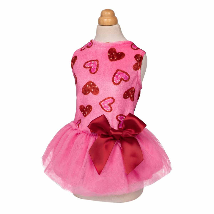 Valentine-themed dog dress with sparkly heart patterns, pink tulle skirt, and red satin bow detail.