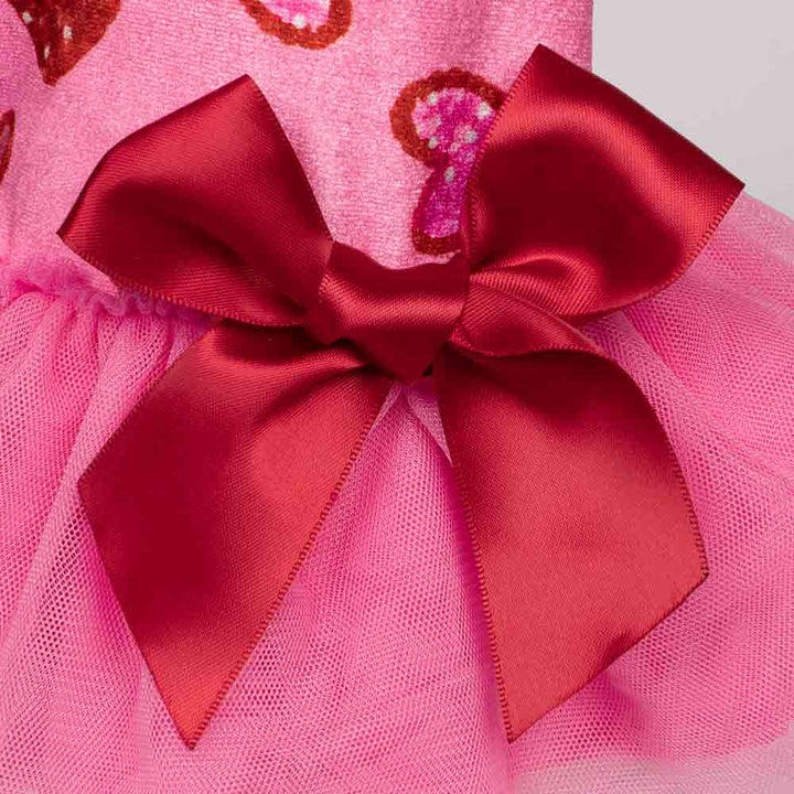 Close-up of pink dog dress featuring a red satin bow and layered tulle skirt.