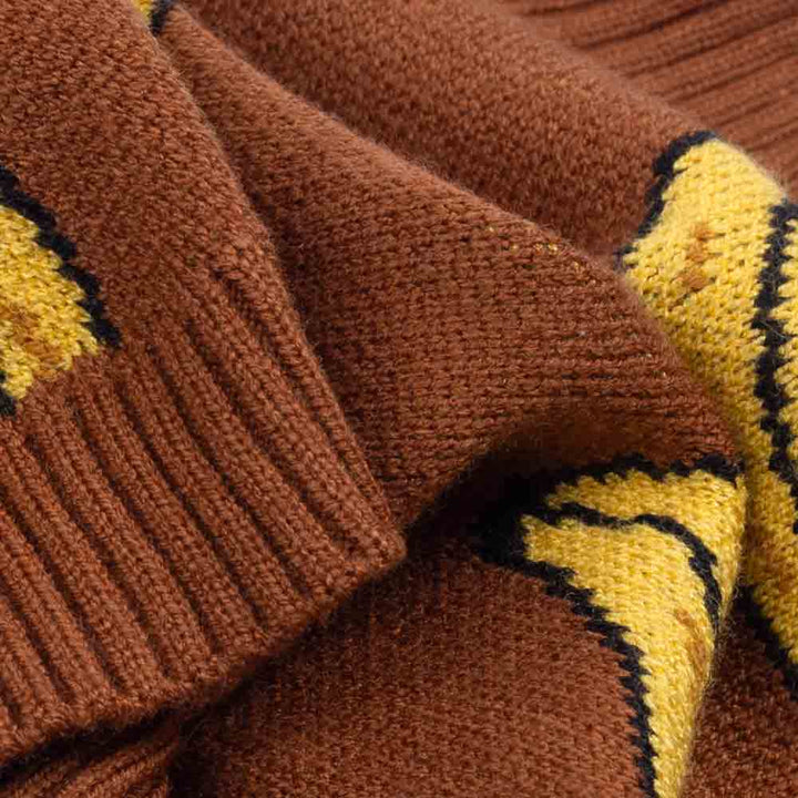 Close-up of a brown dog sweater showing soft knit texture and yellow banana pattern.