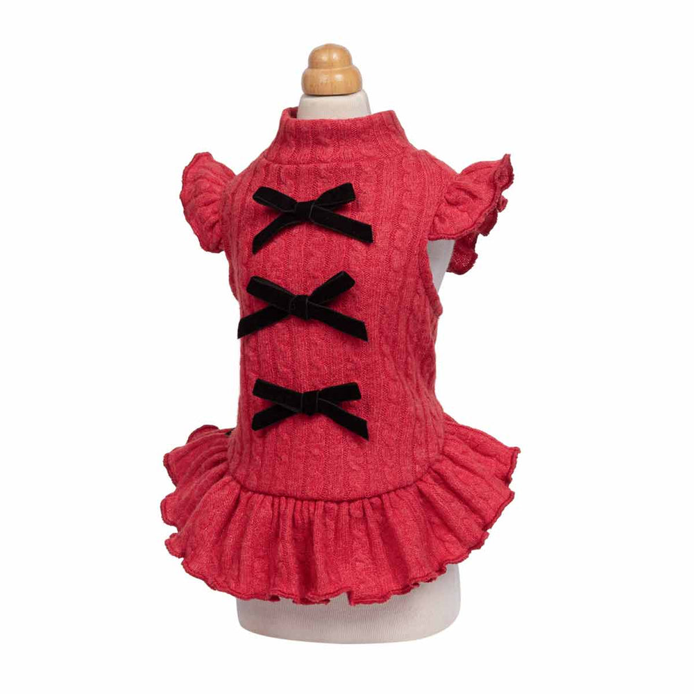 Red textured dog knitted dress with ruffled sleeves and hem, featuring three black velvet bow accents down the front, displayed on a mannequin against a white background