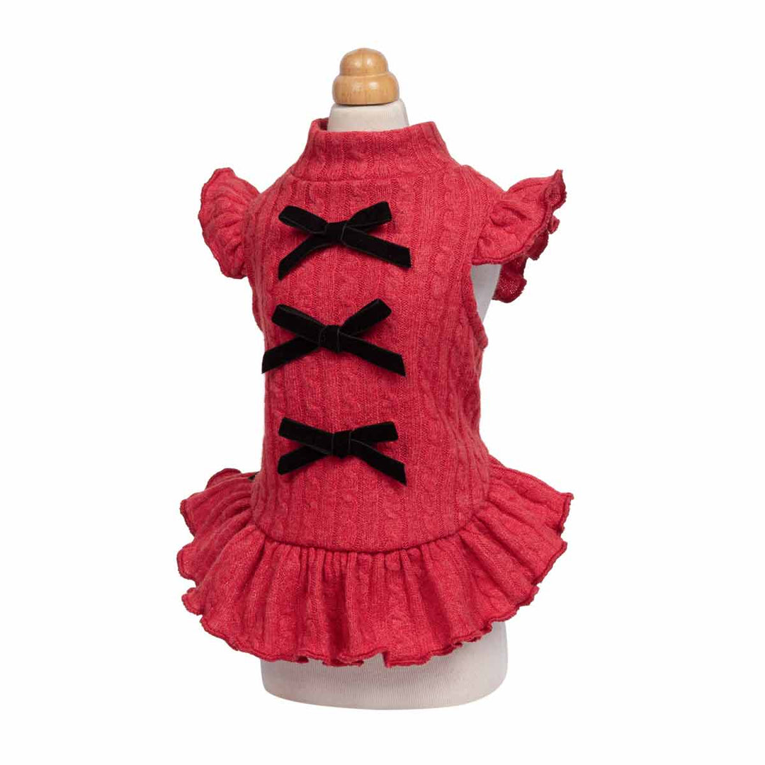 Red textured dog knitted dress with ruffled sleeves and hem, featuring three black velvet bow accents down the front, displayed on a mannequin against a white background