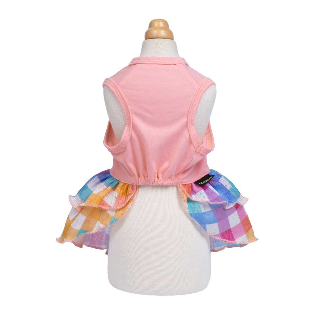Back view of a dog dress with a pink top and colorful plaid skirt with ruffles.