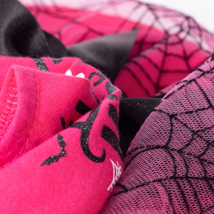 Vibrant pink cotton dog dress detail with glittery 'Bootiful' print, bat graphic, and layered black spiderweb mesh skirt.