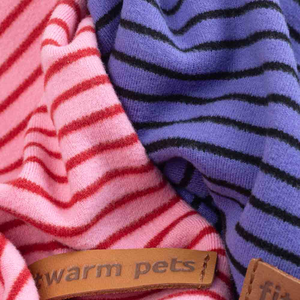 Close-up of striped dog pajamas fabric in pink and purple with Fitwarm logo tag
