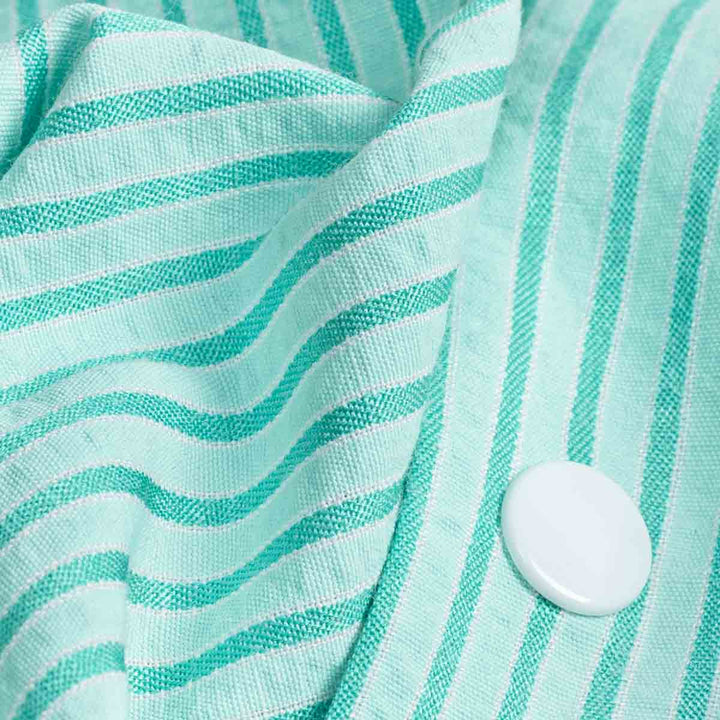 Close-up of a turquoise fabric with white stripes and a button