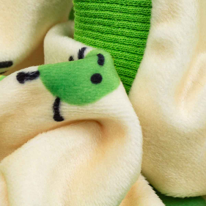 Soft cream dog pajamas with playful cartoon caterpillar print and bright green ribbed cuffs.