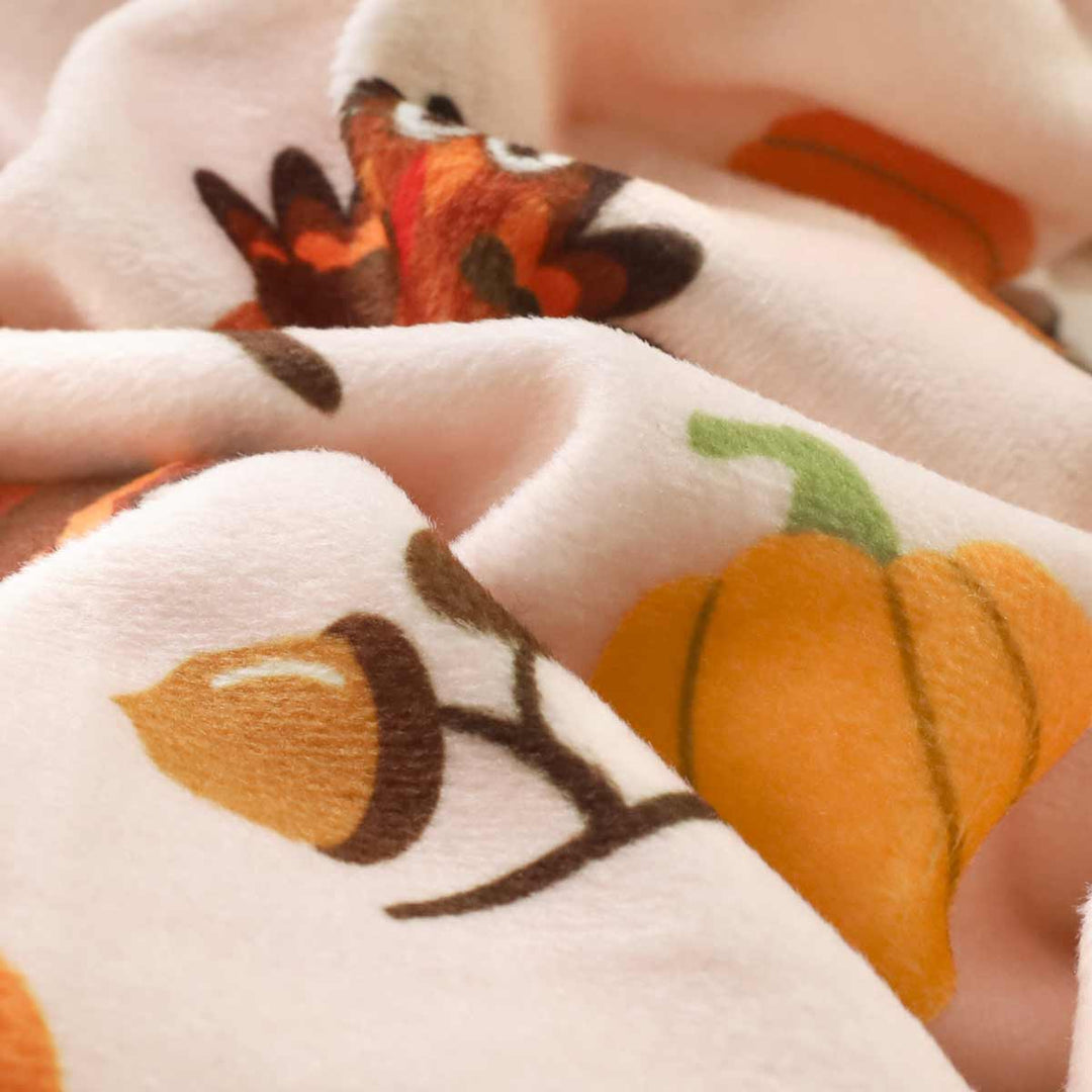 Thanksgiving dog pajamas detail, featuring pumpkin, turkey and chestnut print on soft velvet fabric.