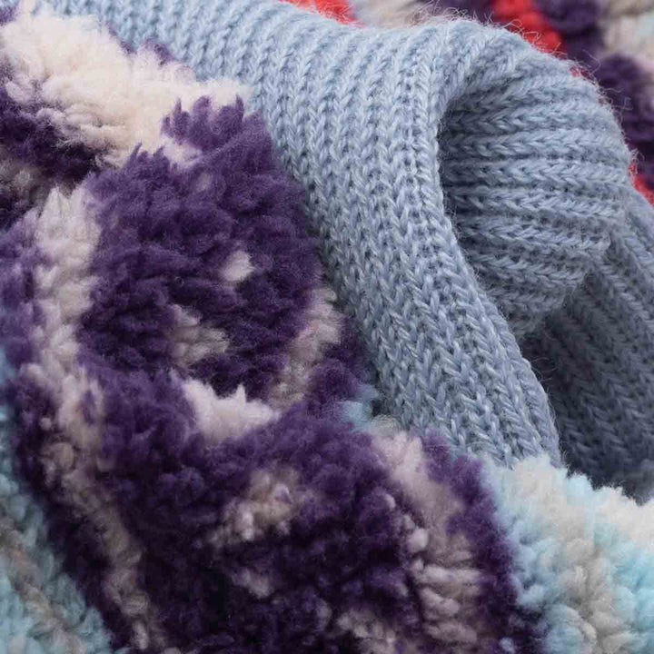 Close-up fabric view of a dog hoodie displaying soft double face fleece with blue knit and multicolor tribal patterns.