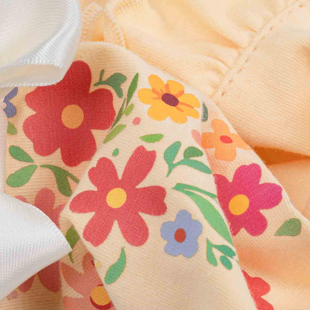 Dog shirt fabric closeup with colorful floral print on cream background