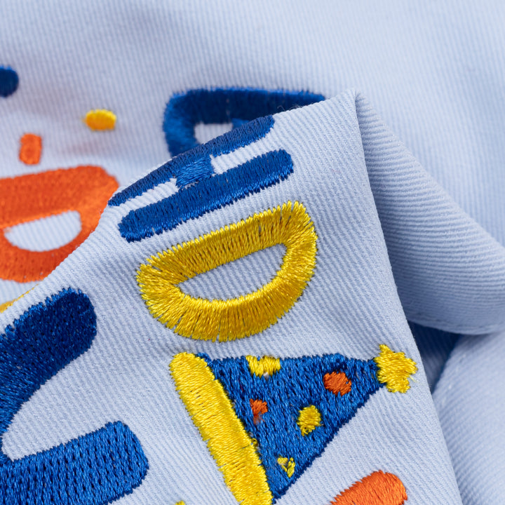 Closeup embroidery detail on Birthday Boy dog bandanas in blue fabric
