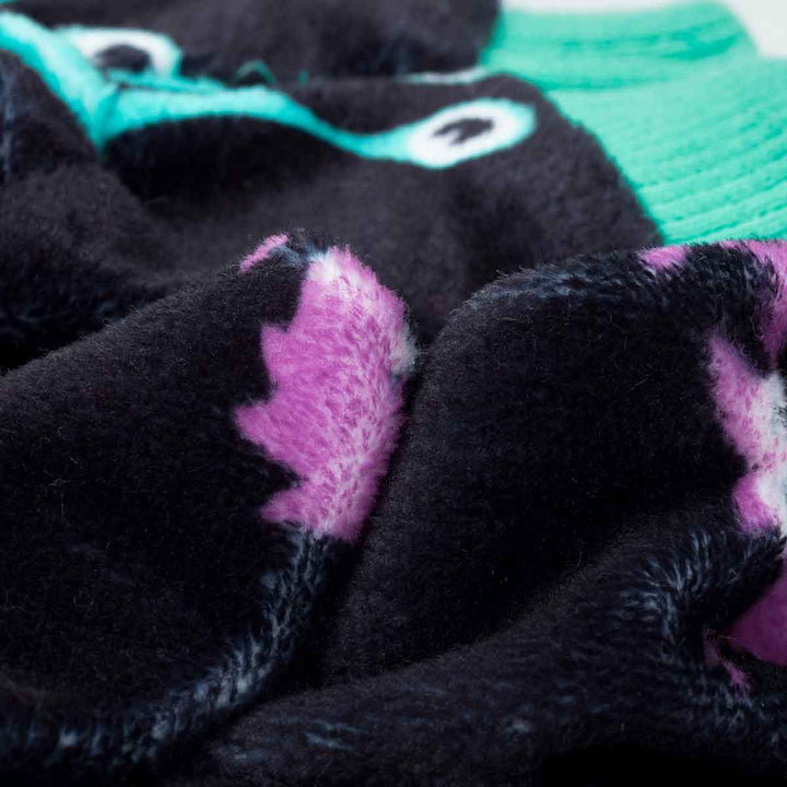 Black dog pajamas with purple and teal cartoon monsters. Cozy Halloween pet wear.