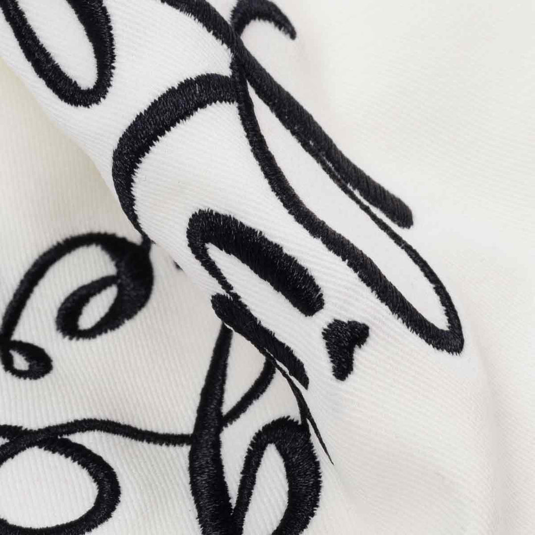 Black embroidered design on a white fabric background