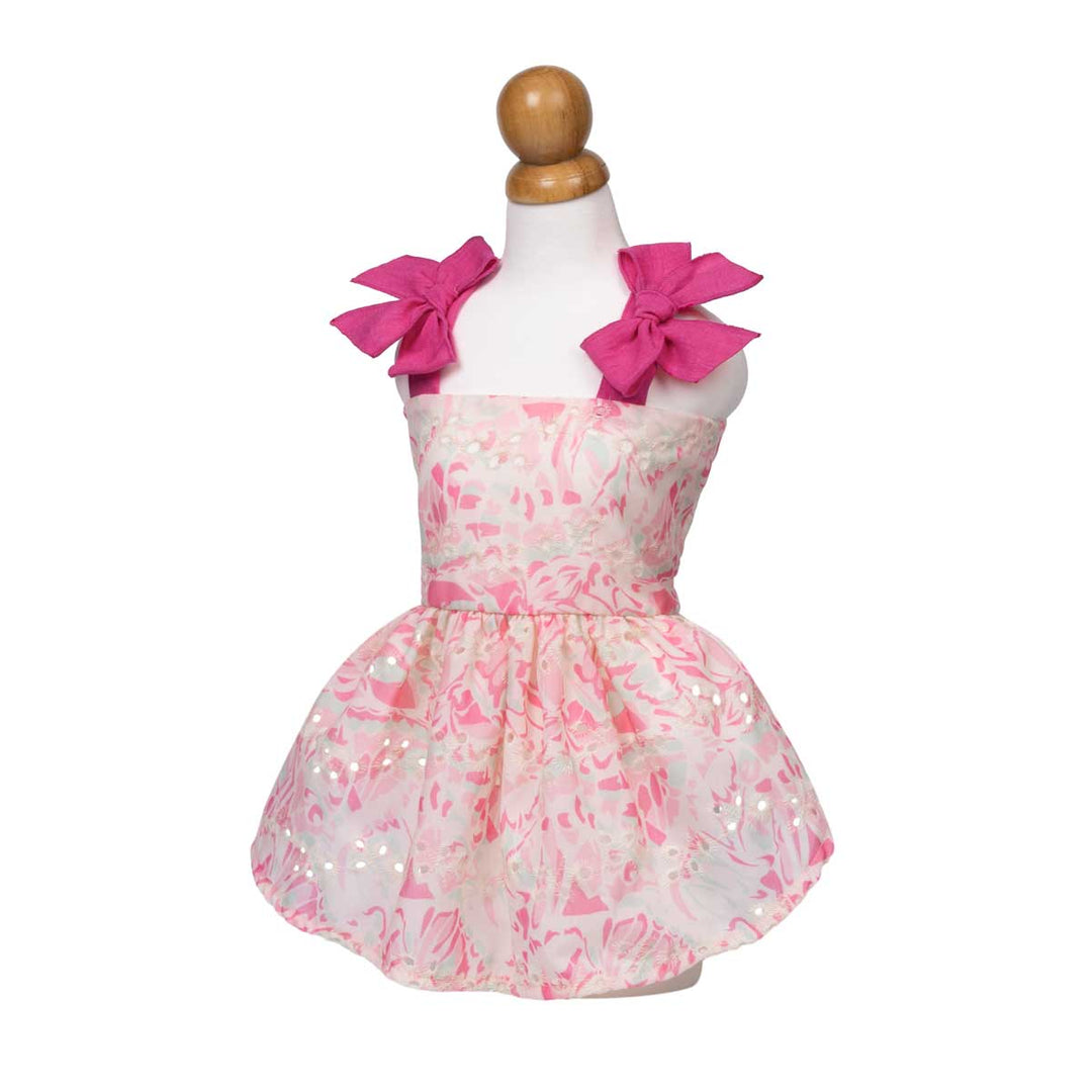 Pink floral dog dress with large bows on a mannequin against a white background