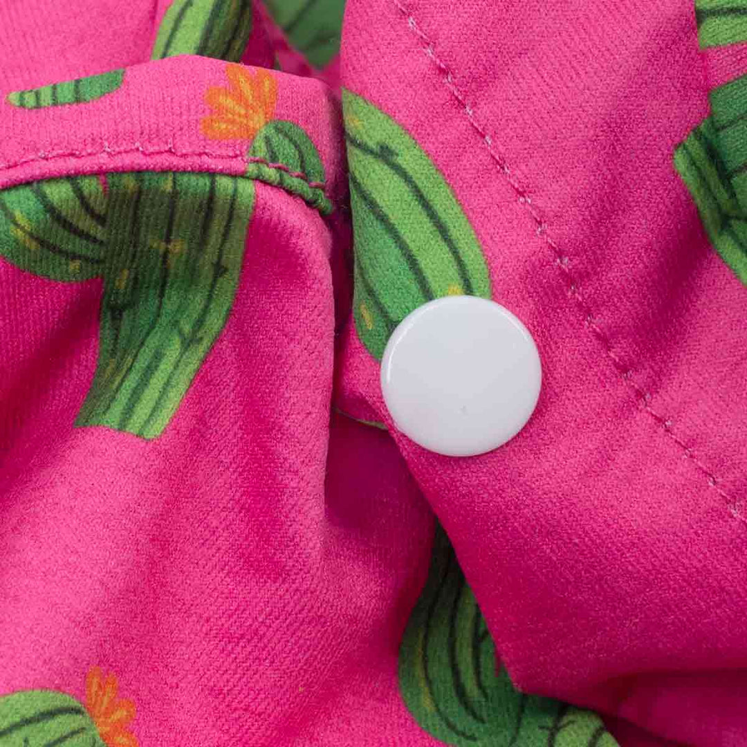 Close up of snap button and fabric detail on pink cactus dog shirt