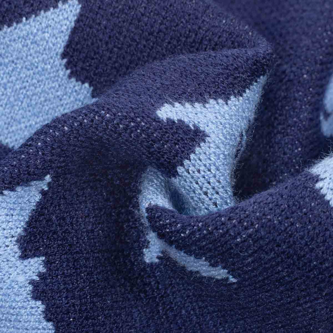 Close-up of a knitted fabric with a dark navy blue and light blue shark pattern