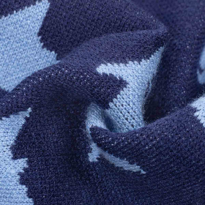 Close-up of a knitted fabric with a dark navy blue and light blue shark pattern