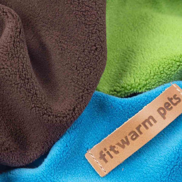 Close-up of a product with 'fitwarm pets' label on blue, green, and brown fabric