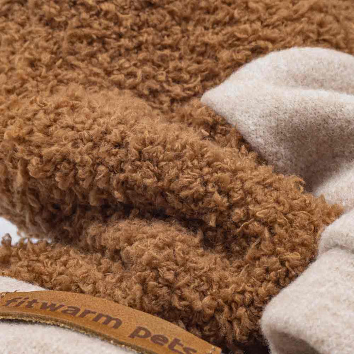 Close-up of a brown textured blanket with a beige corner and a visible brand tag.