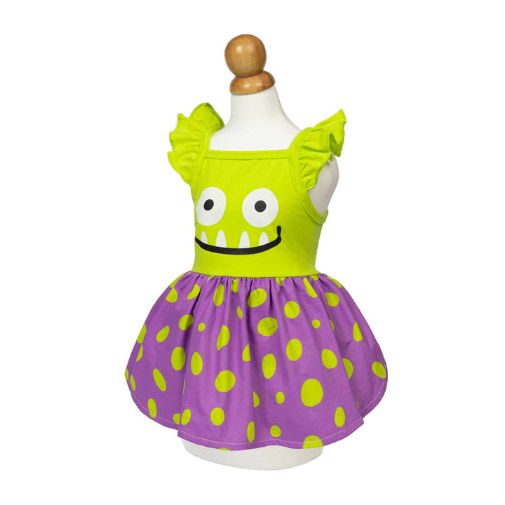 Halloween dress for dogs displayed on a mannequin, featuring a bright lime green top with a monster face graphic and ruffled shoulder straps, paired with a purple polka-dot skirt