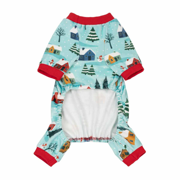 Dog Christmas jumpsuit with a winter holiday print of houses, trees, and snow, featuring red trim and a white belly panel, shown on a plain white background