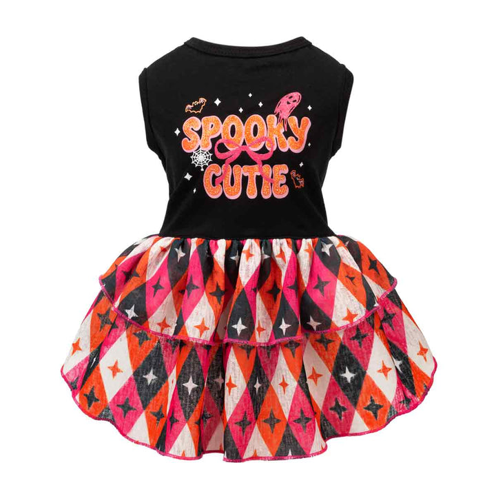 Spooky dress for dogs with a Halloween theme. The top is black with 'Spooky Cutie' printed in orange and pink, and the skirt features a pink, orange, black, and white harlequin pattern with stars
