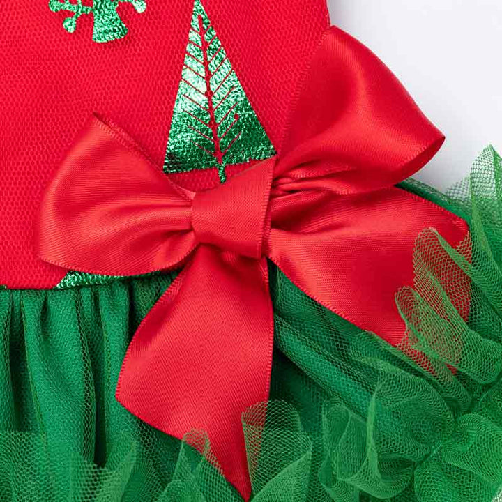 Close-up of red dog dress bodice with shiny green Christmas trees and red satin bow. Layered green tulle skirt.