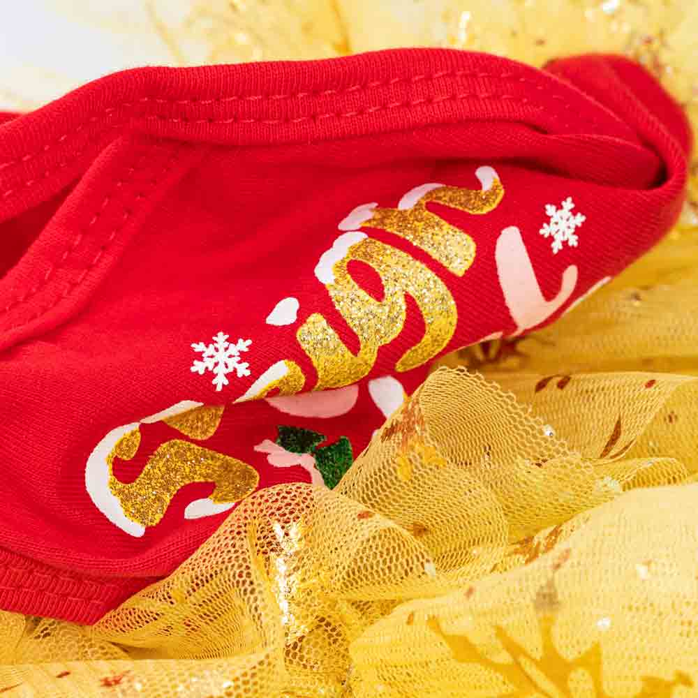 Close-up of red and gold fabric with glitter lettering and mesh from a Christmas dog dress.