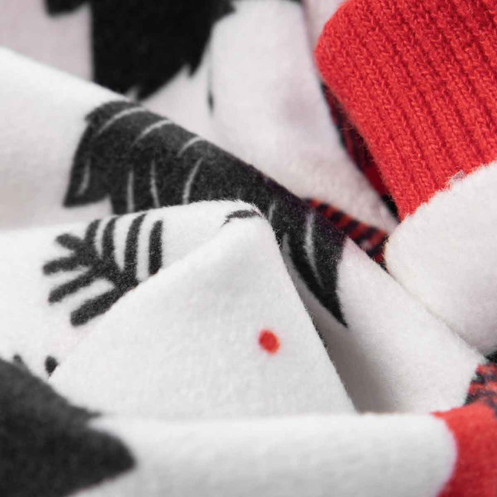 Christmas reindeer dog pajamas fabric: white with black print and red cuff detail. Soft textile.
