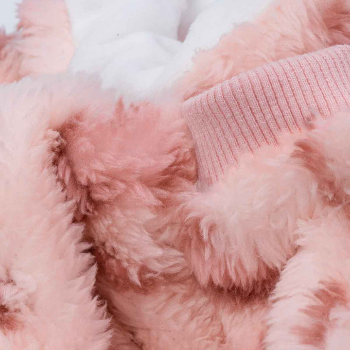 Close-up of fluffy pink dog pajamas showing soft fleece texture and ribbed cuffs.