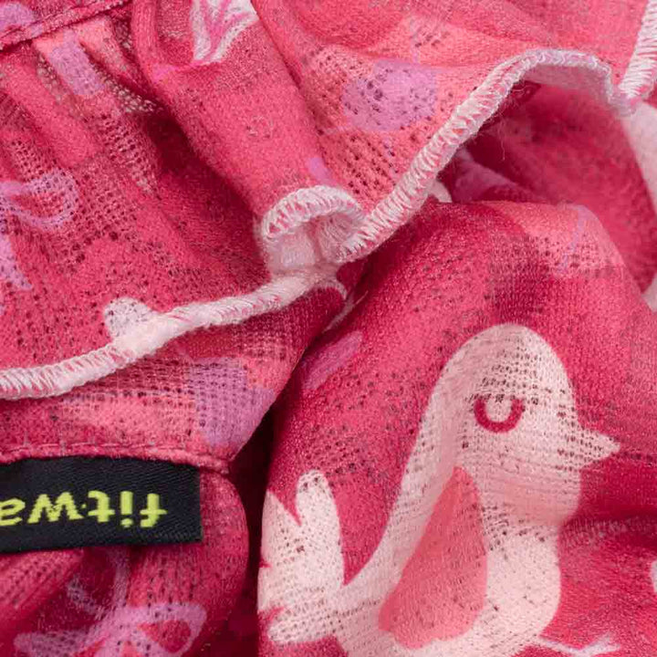Close-up of the dog dress lace fabric showing pink bird patterns and soft textured stitching.