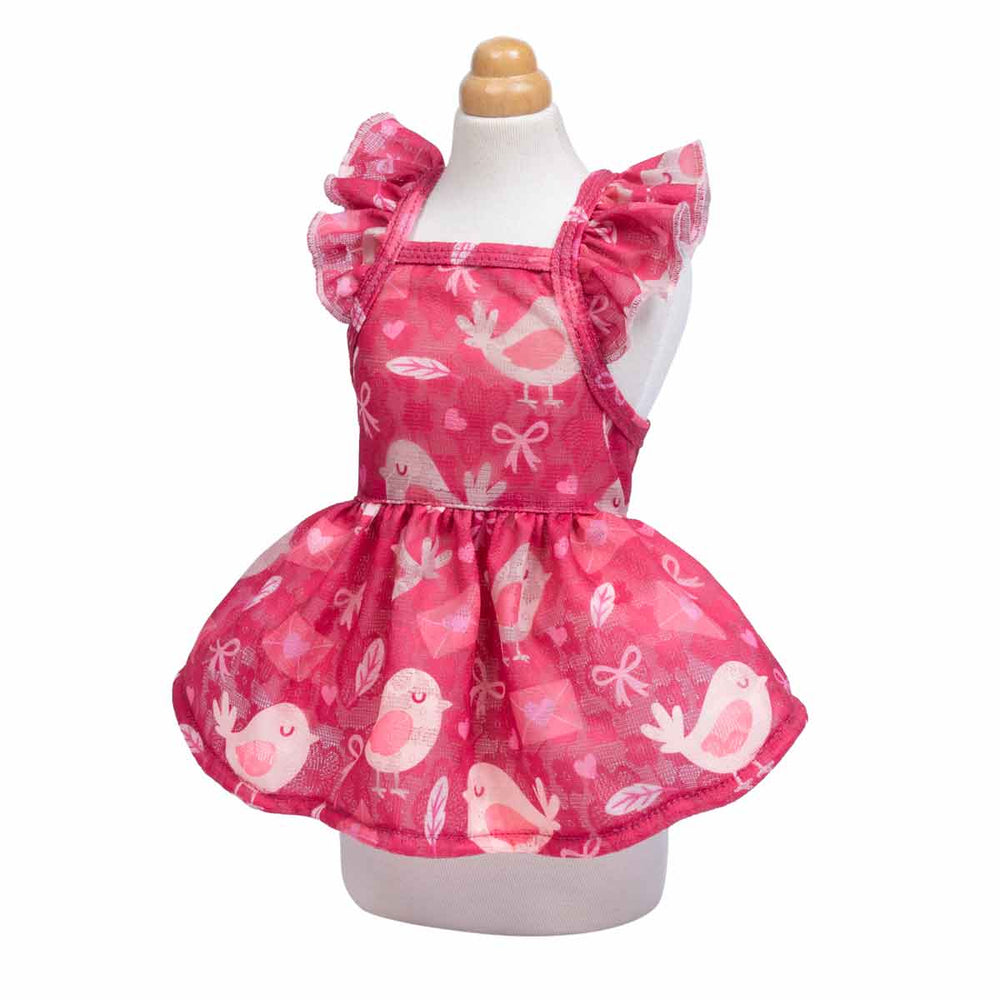 Pink ruffle dog dress featuring cute bird prints displayed on a mannequin from a side angle.