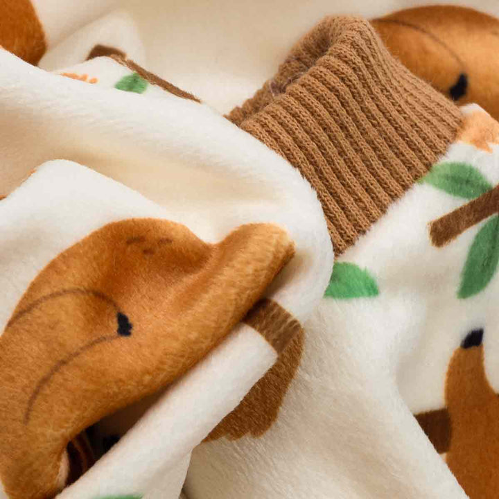 Close-up detail of lightweight velvet fabric on sloth-print dog pajamas.