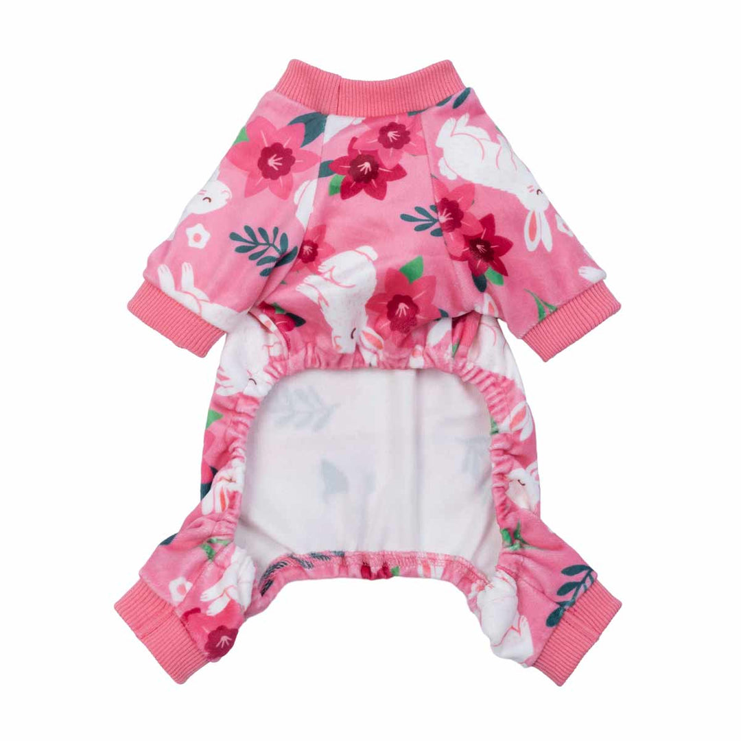 Pink dog pajamas with white bunny and floral prints shown from the underside for fit detail.