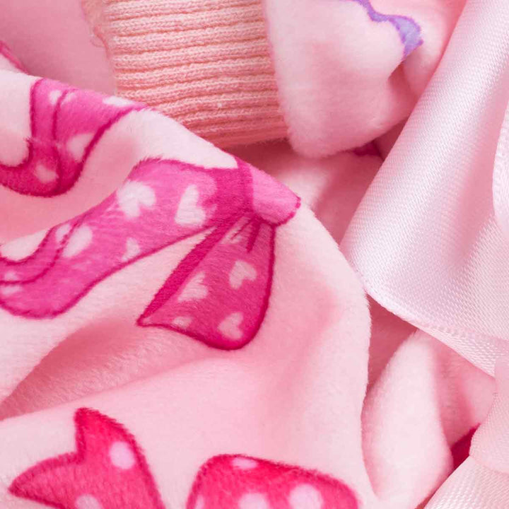 Close up of lightweight velvet dog pajamas fabric featuring soft pink material and bow prints.