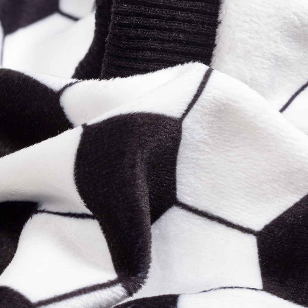 Close up of black and white soccer print fabric on soft lightweight dog pajamas