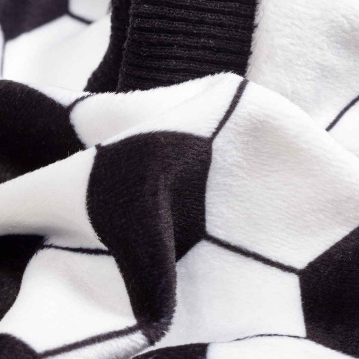 Close up of black and white soccer print fabric on soft lightweight dog pajamas