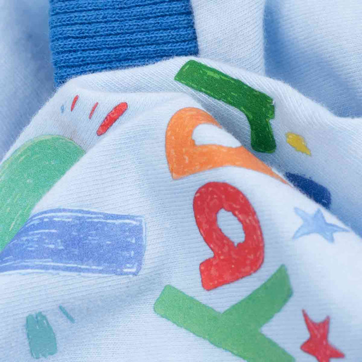 Close-up fabric detail of dog pajamas showing soft cotton blend and colorful printed pattern.