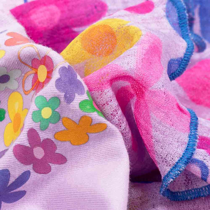 Close-up fabric detail of floral patterned skirt on lightweight purple dog dress.