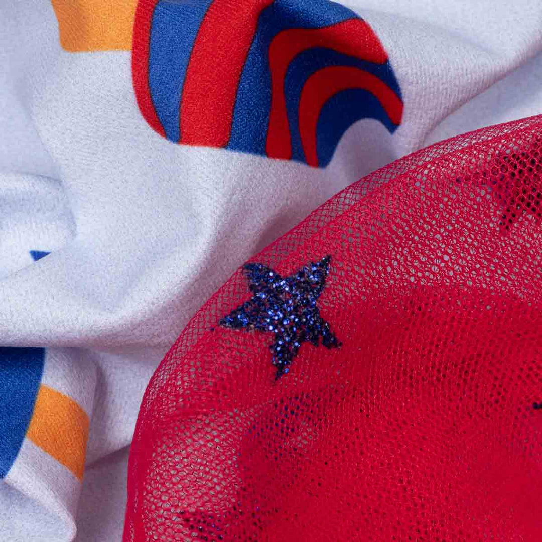 Close-up of colorful fabric with a star design on a red textured surface