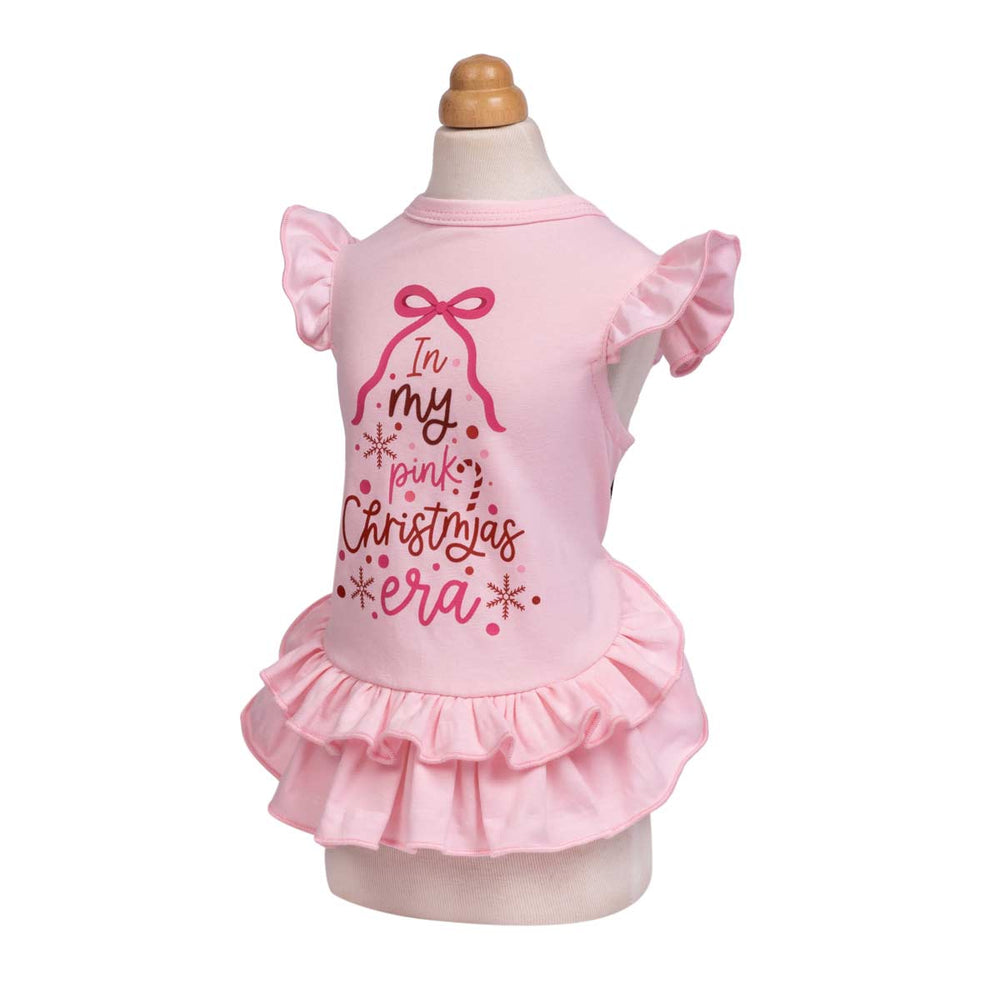 Pink Christmas dress for dogs displayed on a mannequin against a white background, featuring a ruffled sleeves and a ruffled hem, with a graphic on the back that reads 'In my pink Christmas era'