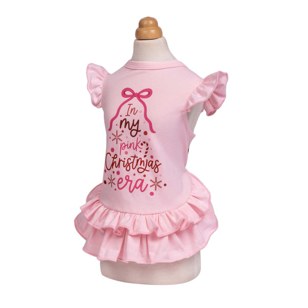Pink Christmas dress for dogs displayed on a mannequin against a white background, featuring a ruffled sleeves and a ruffled hem, with a graphic on the back that reads 'In my pink Christmas era'