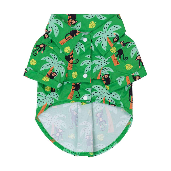 Green dog shirt with monkey and palm tree pattern on a white background