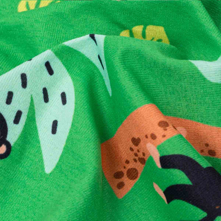 Close-up of a green fabric with monkey and palm tree patterns
