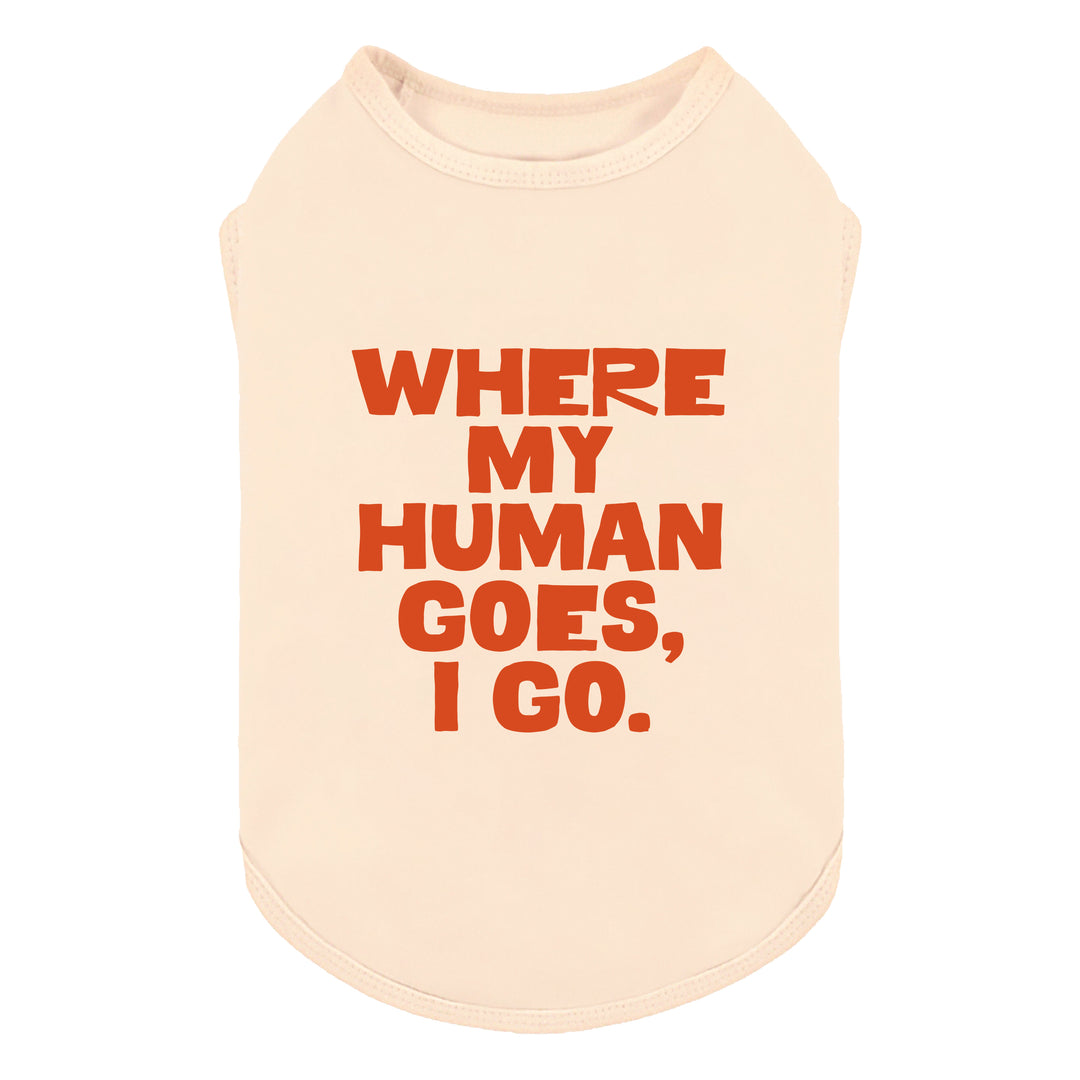 Cream-colored sleeveless shirt for dogs with bold orange text reading 'WHERE MY HUMAN GOES, I GO.' on a plain white background