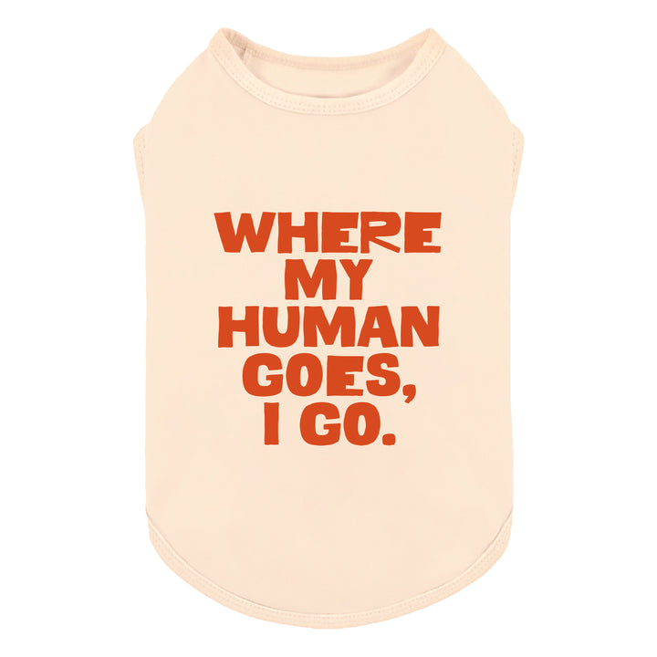 Cream-colored sleeveless shirt for dogs with bold orange text reading 'WHERE MY HUMAN GOES, I GO.' on a plain white background