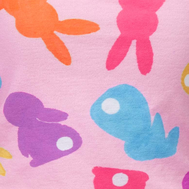 Close-up of vibrant bunny prints on a pink dog dress, showcasing a playful design.