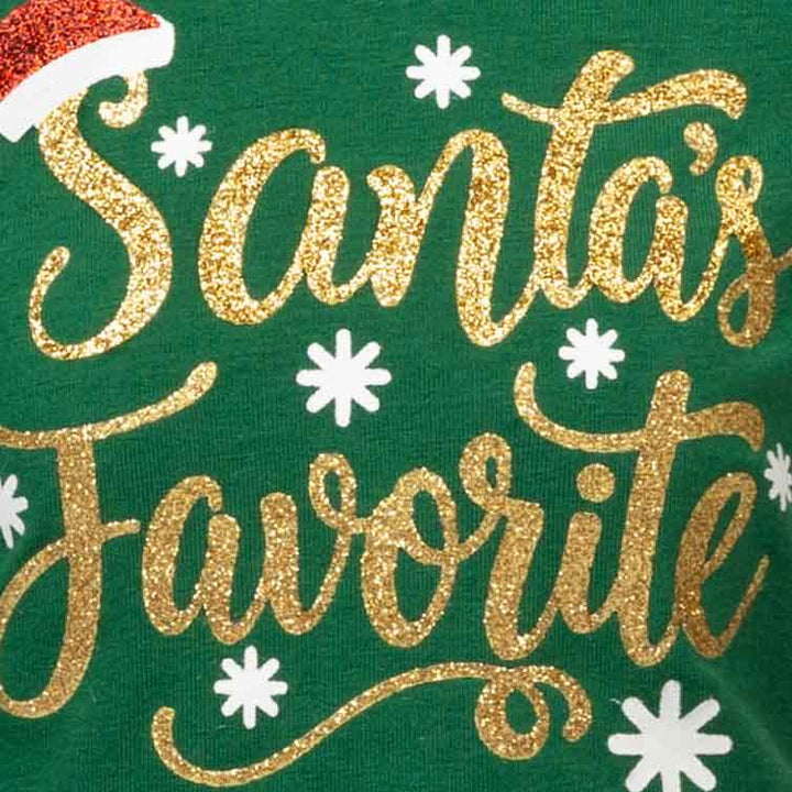 Close-up of a green fabric surface with large glittery gold script reading "Santa's Favorite" and small white snowflake motifs