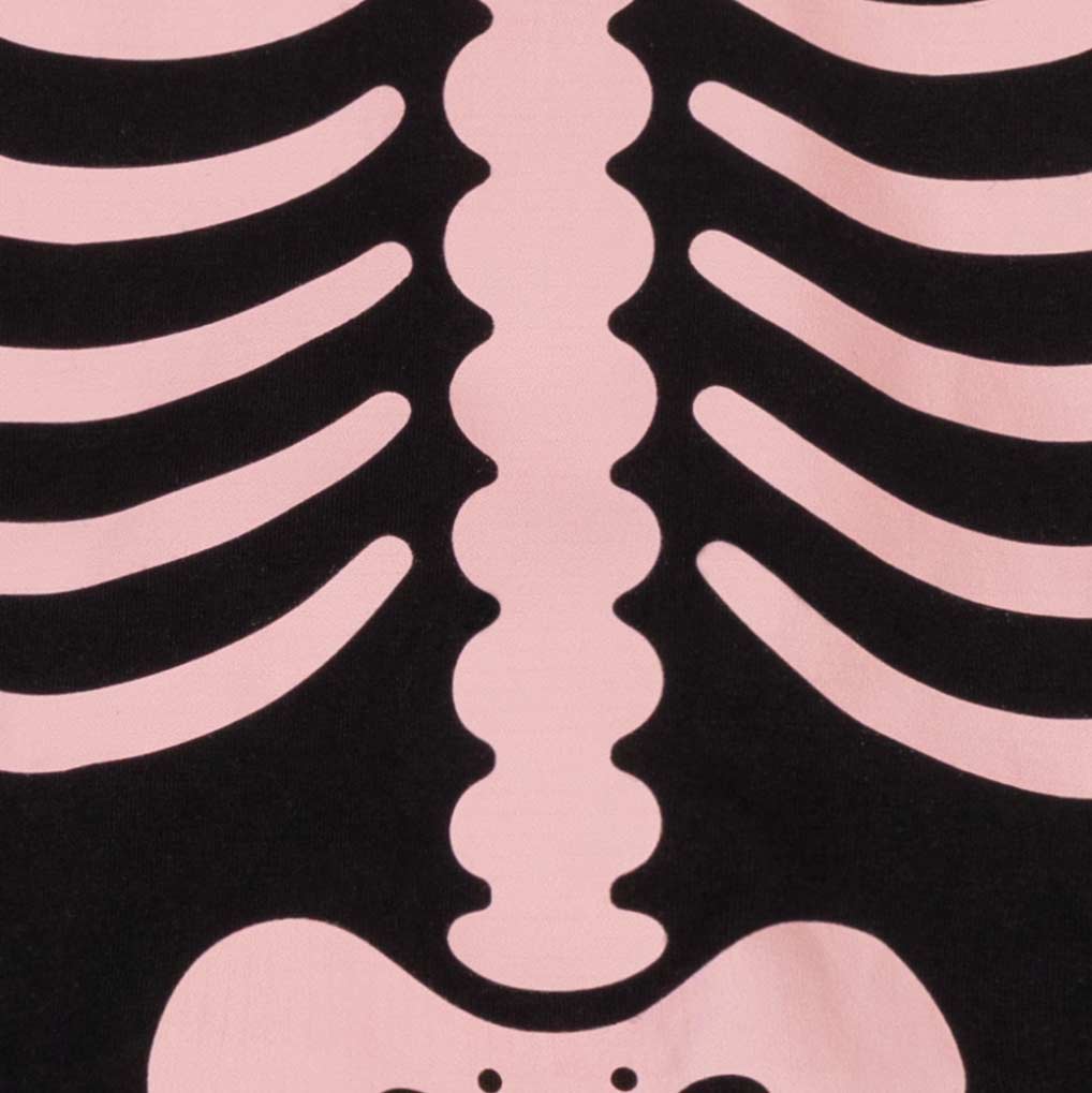 Close-up of black pajamas for dogs featuring a light pink rib cage and spine skeleton graphic