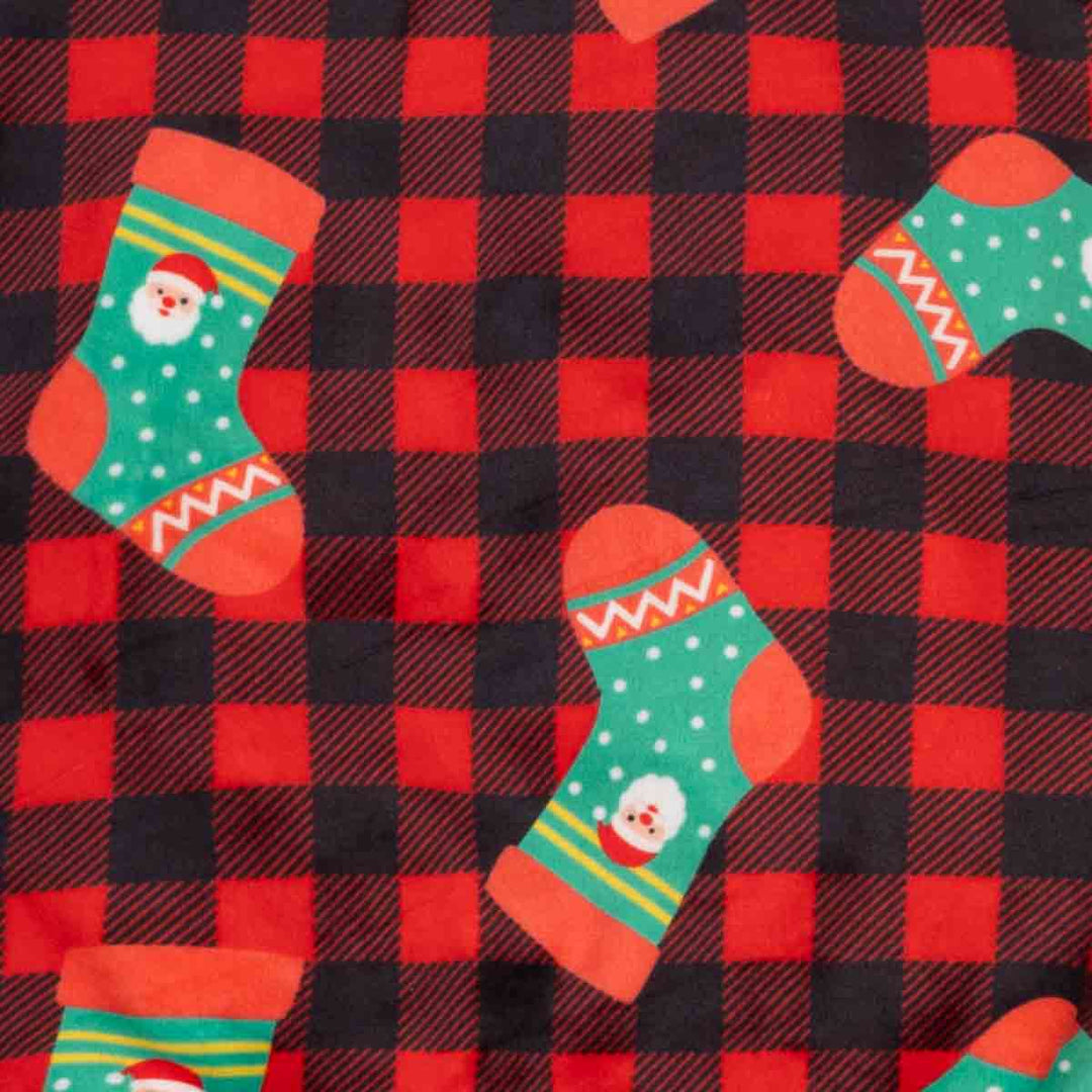 Close-up of a fabric pattern featuring a red and black buffalo plaid background with scattered Christmas stockings